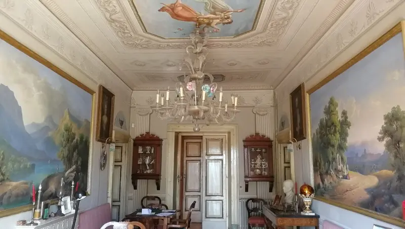Il salotto attiguo alla Suite Baldacchino, con soffitto decorato e lampadario