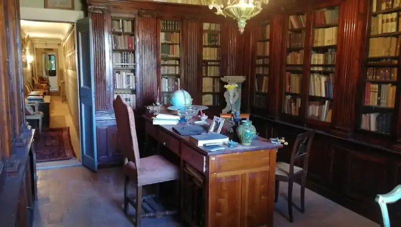 La biblioteca storica della dimora, con le scaffalature in legno e lo scrittoio