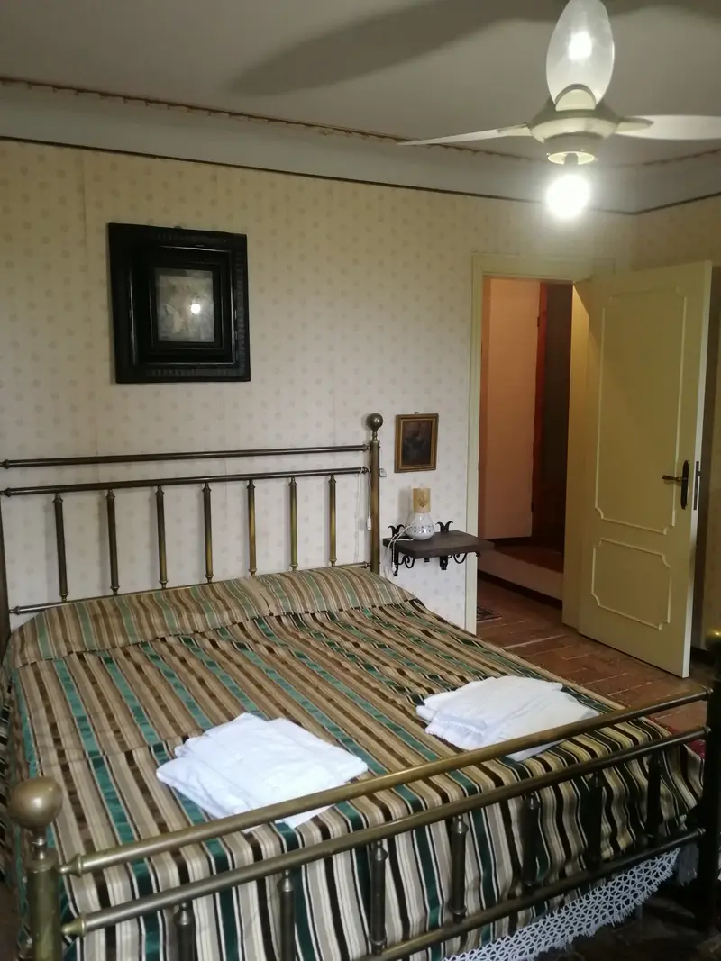 La camera principale della Suite al secondo piano, con letto in ottone e copriletto a righe