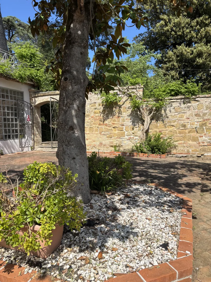 La Segreta, patio rialzato che guarda dall'alto il verde degli otto ettari di Villa Luzi