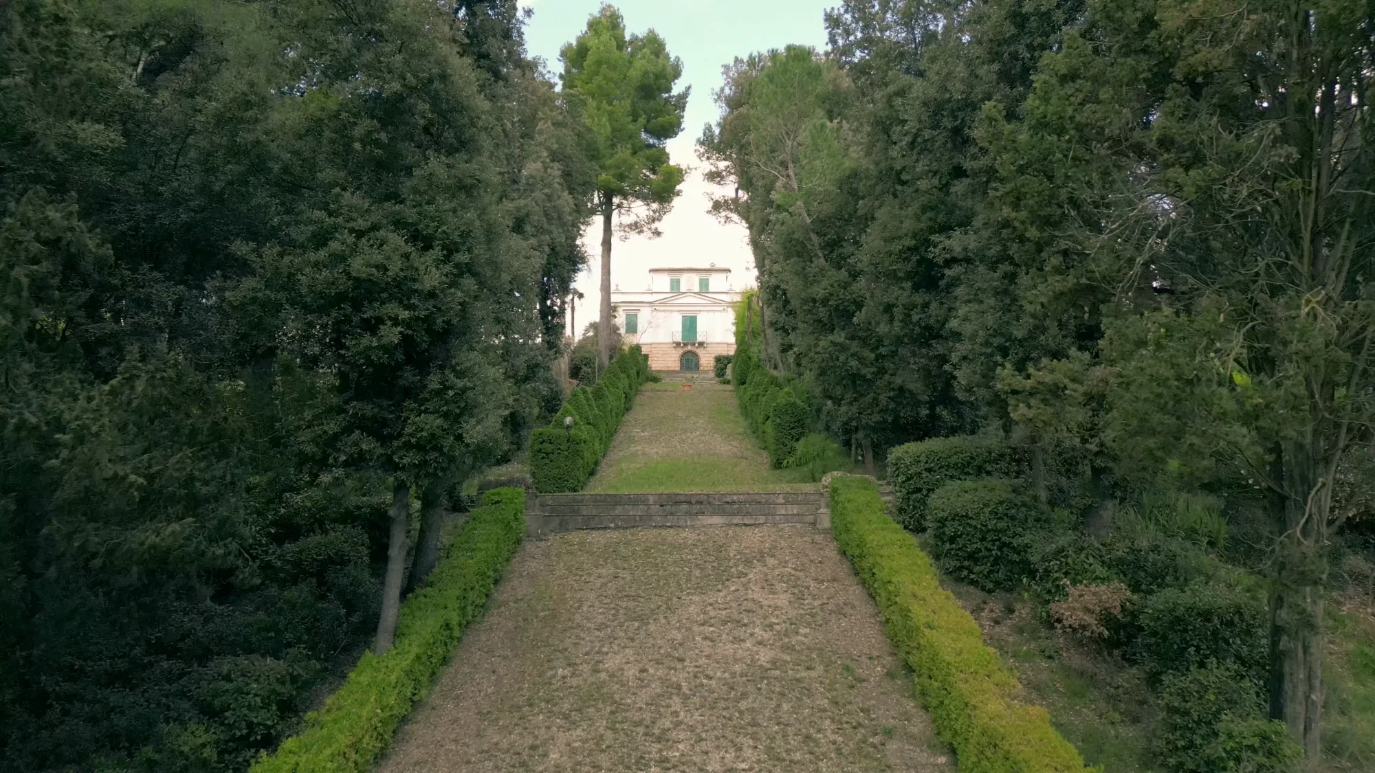 Il viale dei cipressi che conduce all'ingresso di Villa Luzi, con la facciata della dimora storica sullo sfondo