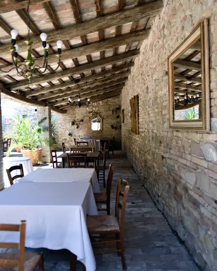 Il portico del cortile di Villa Luzi, con le tavole apparecchiate lungo il muro di pietra