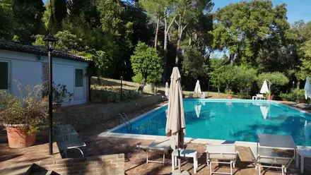 La piscina di Villa Luzi fra gli alberi del parco, in una giornata di sole