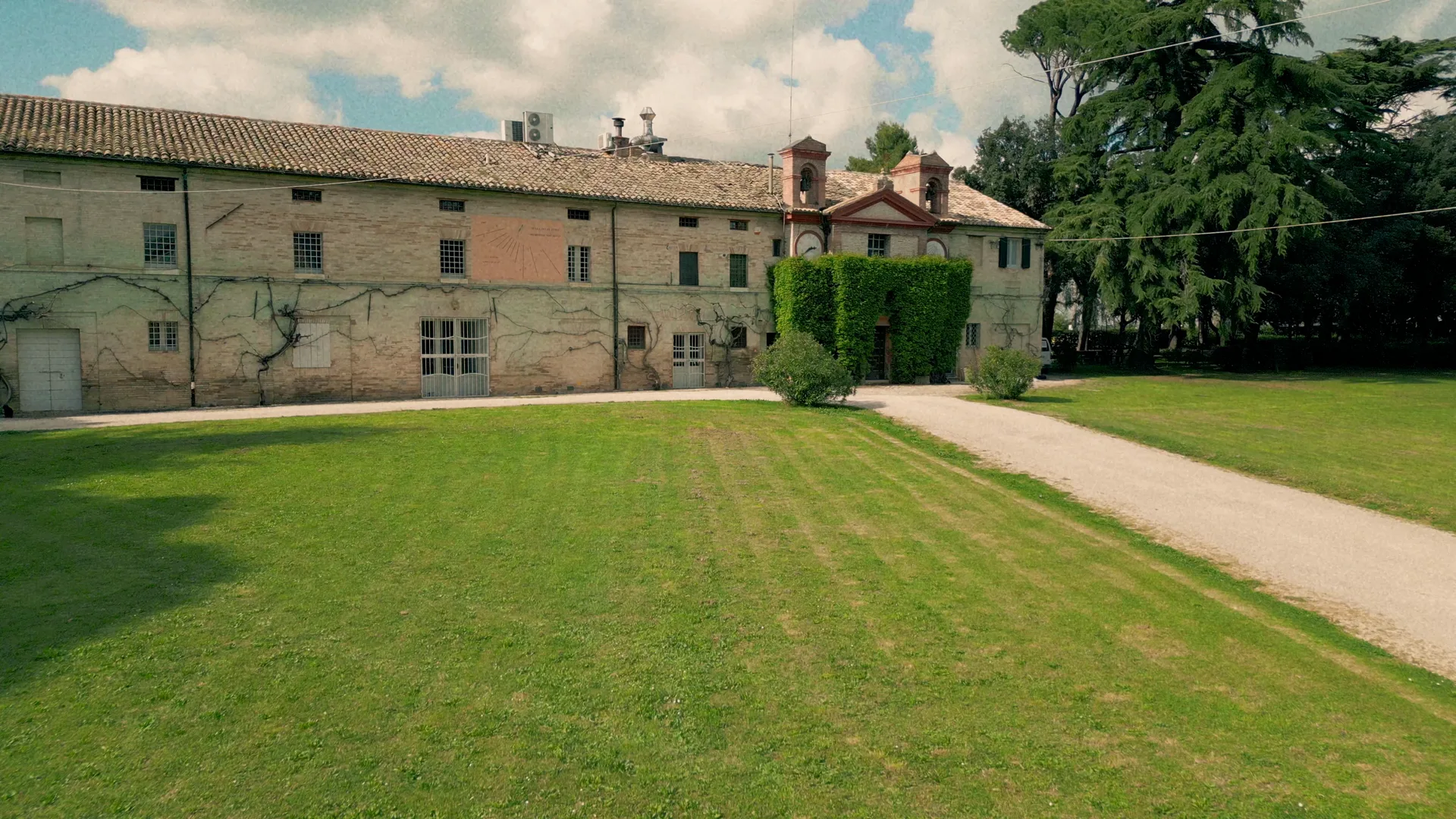 La palazzina padronale di Villa Luzi e gli otto ettari di parco a Treia, nelle Marche, visti dal grande prato all'inglese